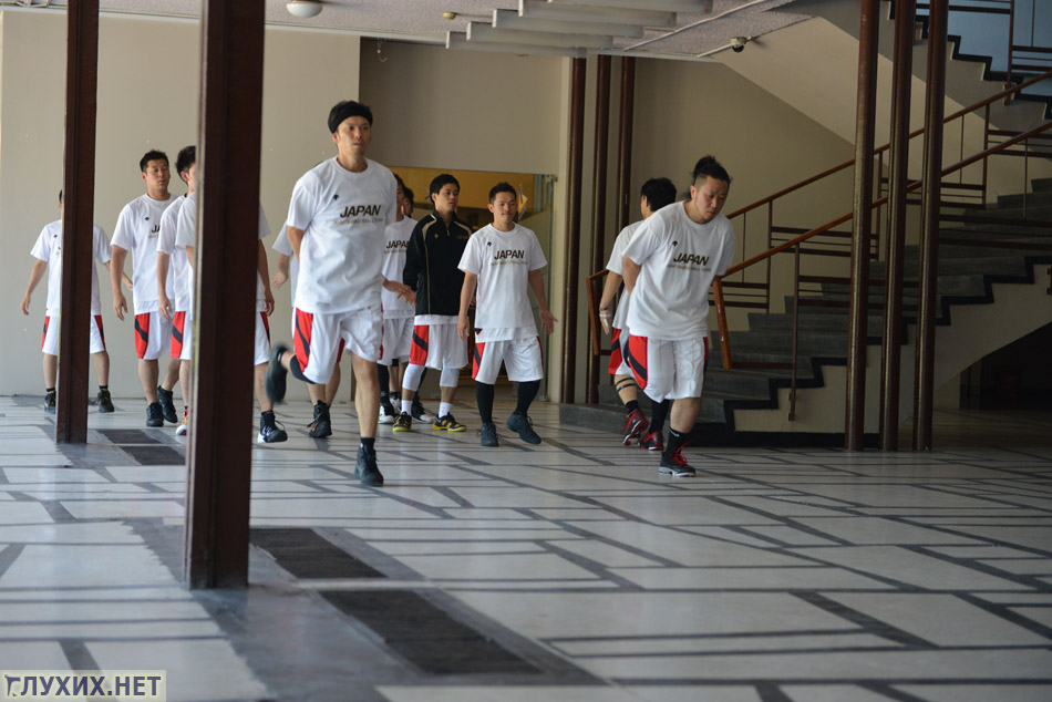 Сборная Японии по баскетболу разминаются в холле.